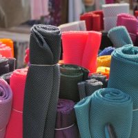 Vibrant rolls of mesh fabric displayed at a market in Mayen, Germany.